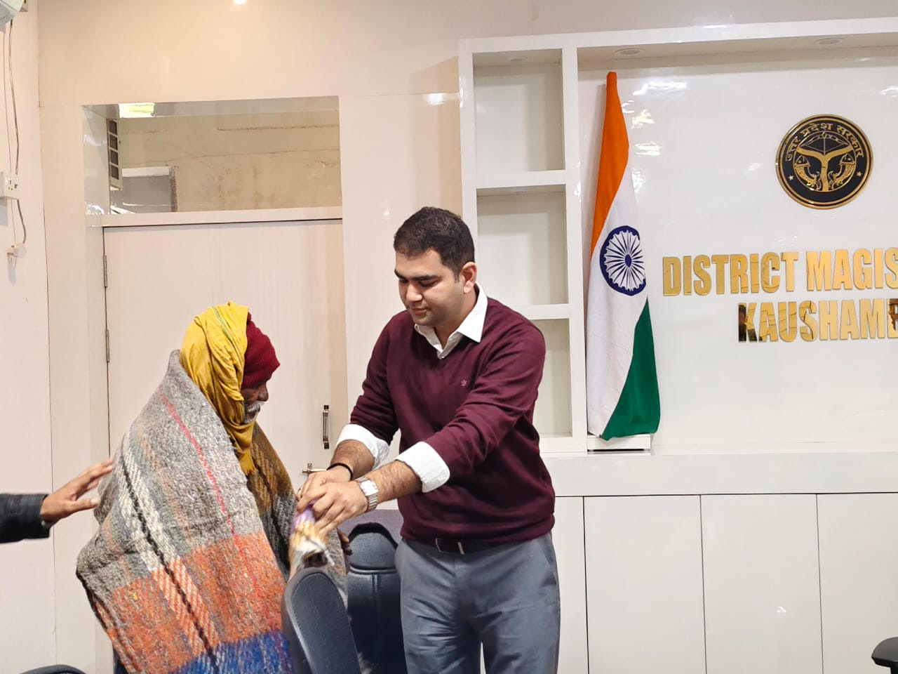 The District Magistrate gave a blanket to an old man who came for public darshan.